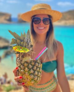 Lady holding pineapple cocktail in comino blue lagoon
