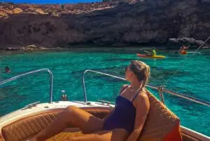Lady sunbathing on boat prow near Cominotto Island Malta during private boat tour