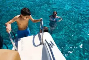 Kid climbing boat stairs during a Blue Lagoon Comino Malta private boat trip.