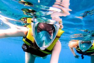 Guest snorkelling in crystal clear blue water near Comino Malta, exploring marine life during a private boat trip