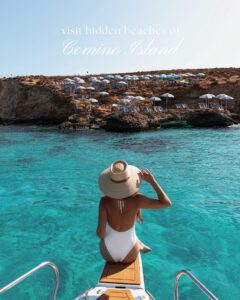 Woman sitting on the front jump platform of a private boat at the Blue Lagoon Malta, surrounded by clear turquoise waters.