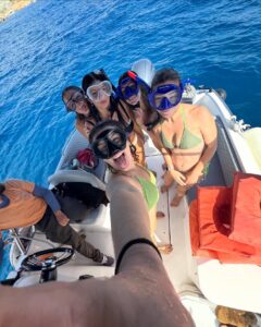 Guests snorkeling during a private boat trip at Comino Malta, exploring clear blue water and marine life near the island.
