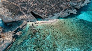 Hidden cave near Cominotto Island by the Blue Lagoon Malta, featuring turquoise water and a secluded entrance accessible by private boat.