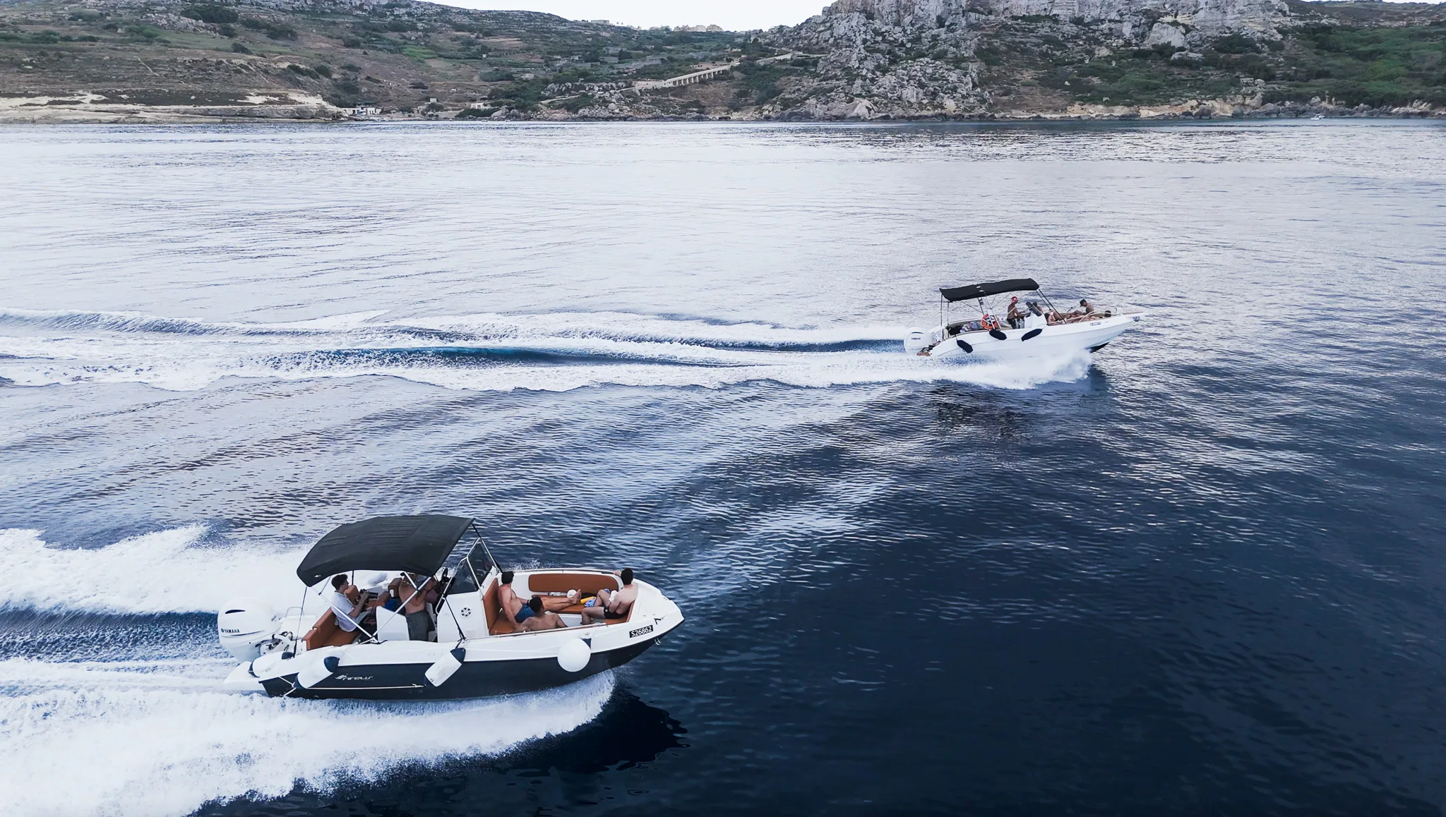 Fast boat cruising toward the Blue Lagoon Malta, cutting through clear blue water on the way to Comino Island.
