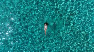 Person floating in the Blue Lagoon Malta, surrounded by clear turquoise water during a calm private boat experience near Comino.