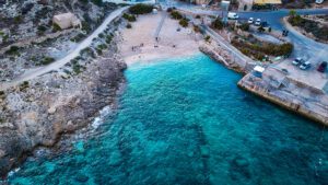 Hondoq Bay Gozo Malta drone shot showing turquoise water beach and cliffs perfect location for private boat tour swimming and snorkeling