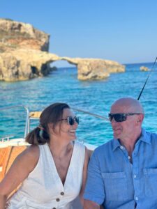 Two seniors enjoying a private boat tour in Malta, relaxing on calm blue waters during a comfortable and exclusive boat experience.