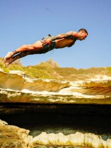 Head dive into blue water at St Peter’s Pool Malta