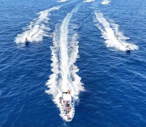 Jet ski safari in Malta riding fast behind boat near Comino coastline